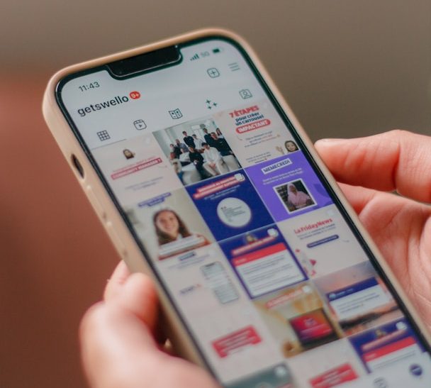 Strategie Eine Hand hält ein Smartphone, das eine Social-Media-App mit visuellen Inhalten zeigt.